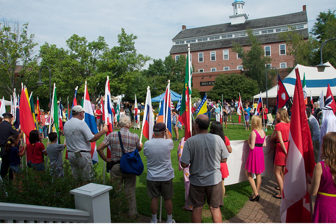Multicultural Festival flag holders with Belknap Mill in the background
