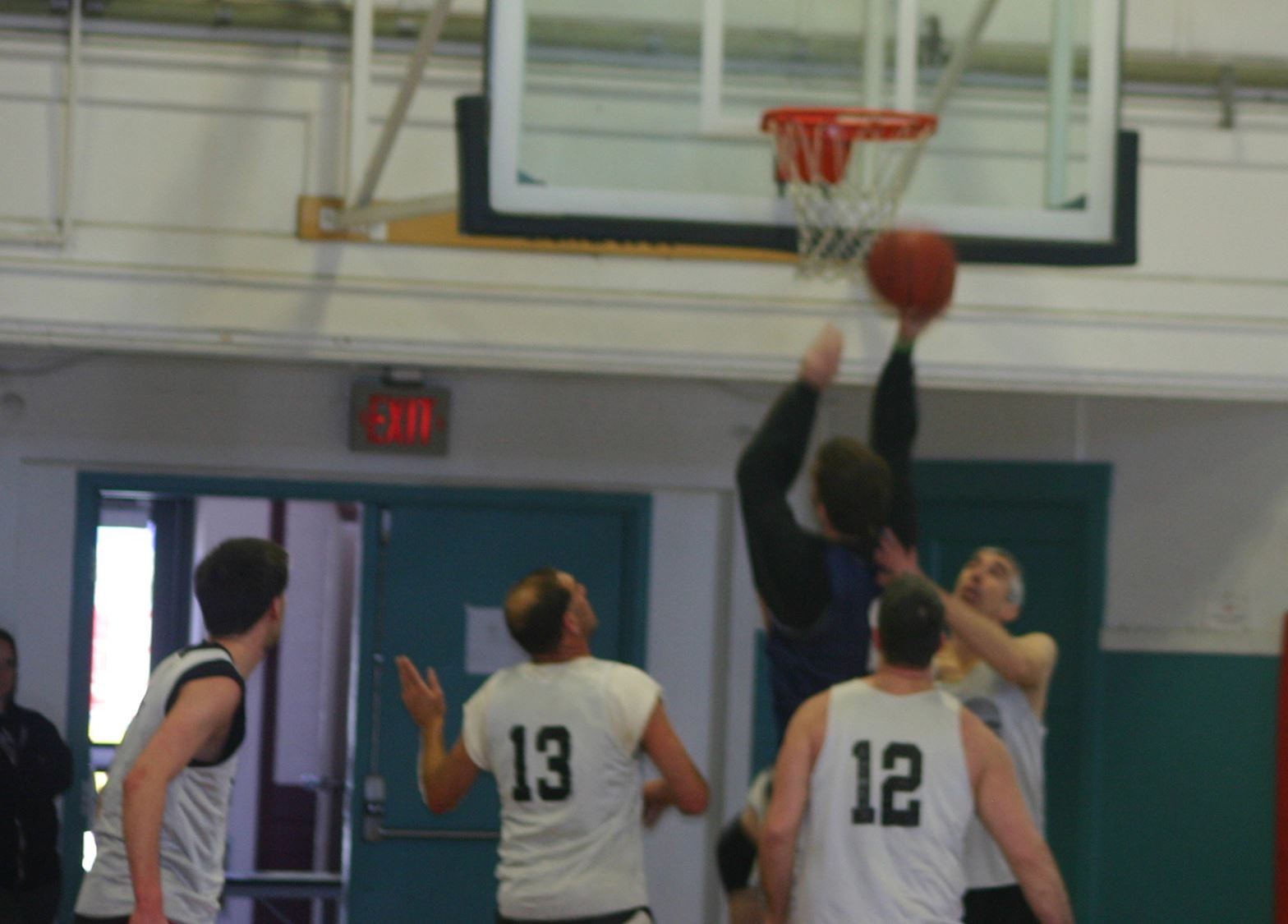 A photo of men playing basketball in the community center